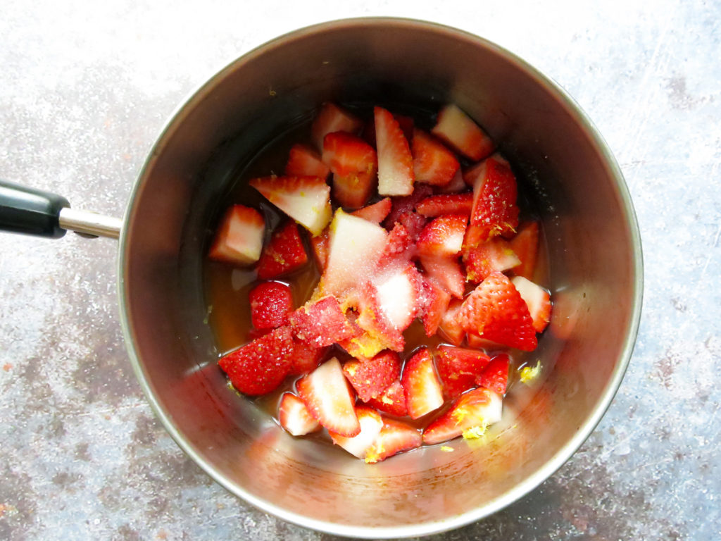 Strawberries with sugar and zest in a pot