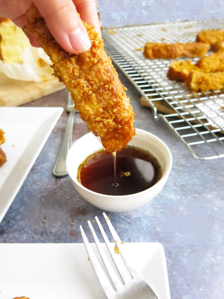 Cinnamon and Cornflake Crusted French Toast Sticks dipped in maple syrup