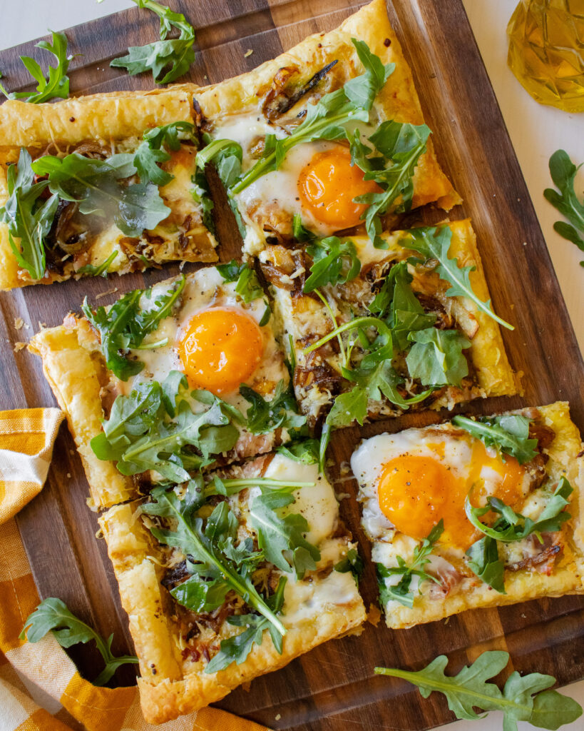 wide overhead shot of slices of Breakfast Puff Pastry Tart on a cutting board