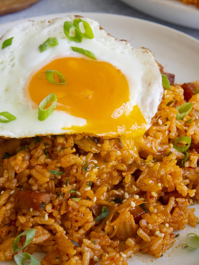 close up with spam & kimchi fried rice with a fried egg on top with a runny yolk