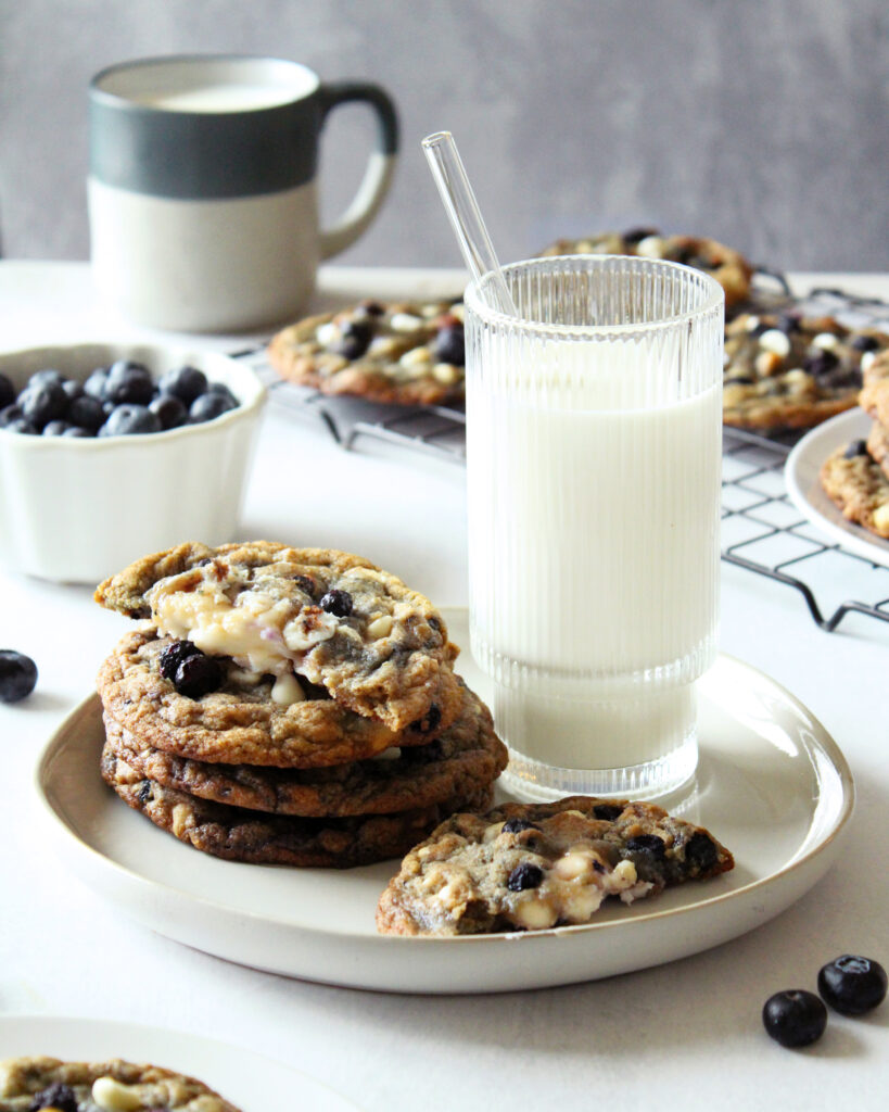 Stack of Blueberries and Cream Cookies with milk and one broken in half