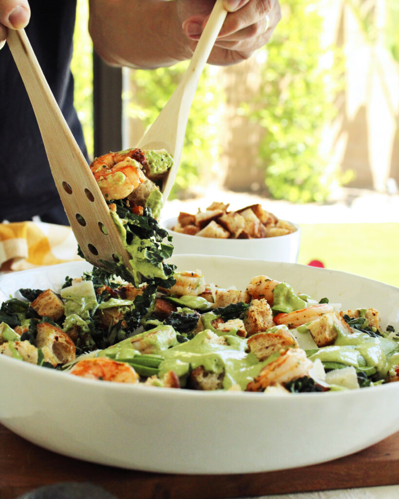 Tossing Green Goddess Kale Caesar Salad