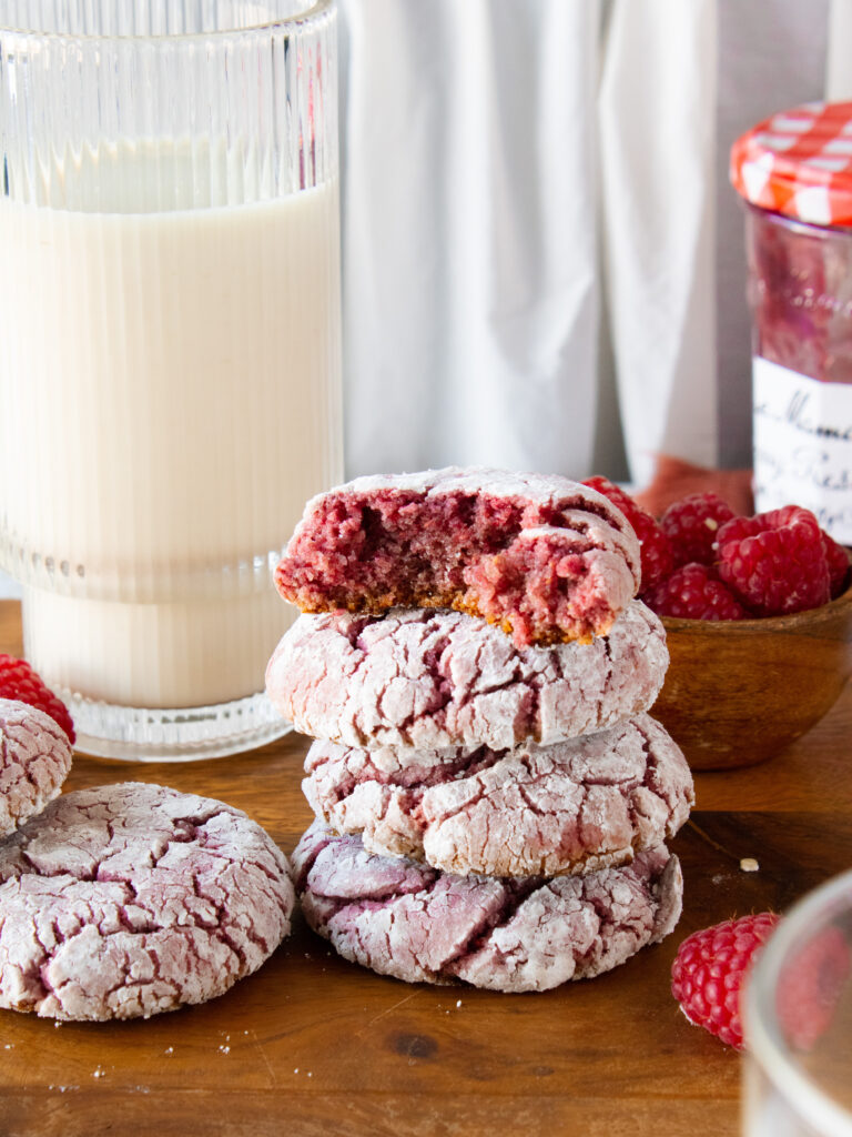 stack of raspberry crinkle cookies with one bit in half