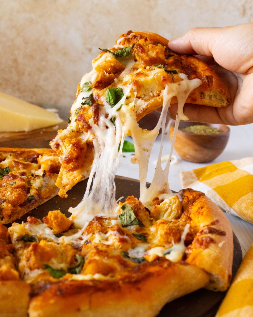 Shot of a cheese pull slice from Chicken Parmesan Pizza