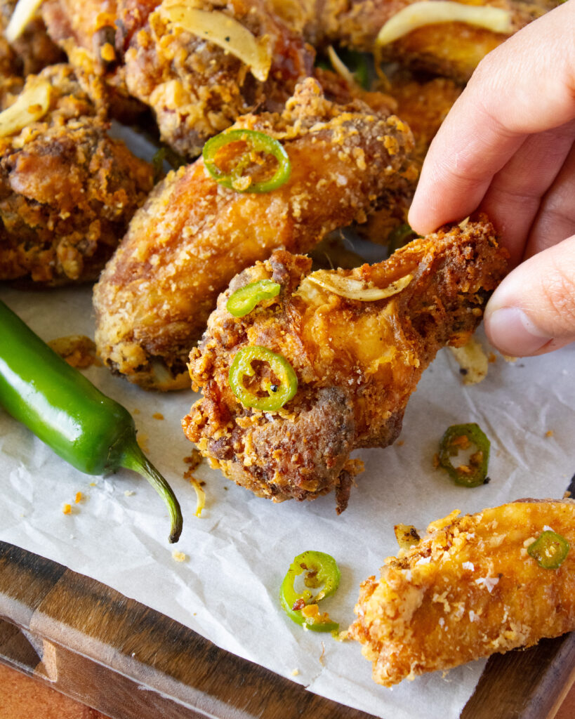 close up of picking up a Salt and Pepper Chicken Wings drumstick