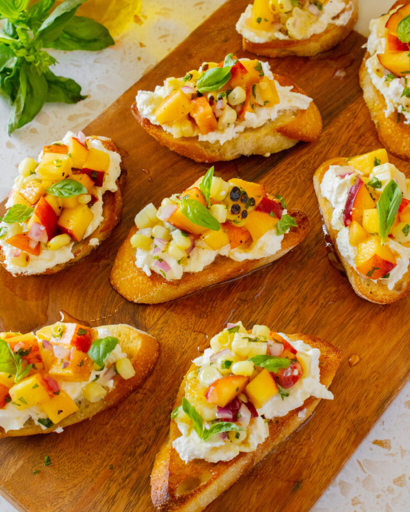 Peach and Corn Burrata Crostini on a cutting board