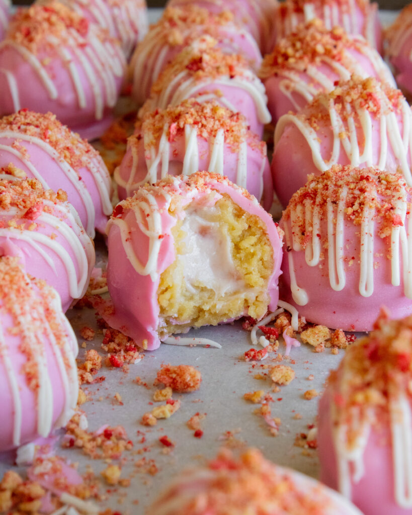 Strawberry Shortcake Cheesecake Truffle with a bite taken out
