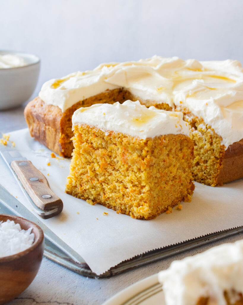 slice taken out of Tahini Carrot Cake with Salted Maple Whipped Cream