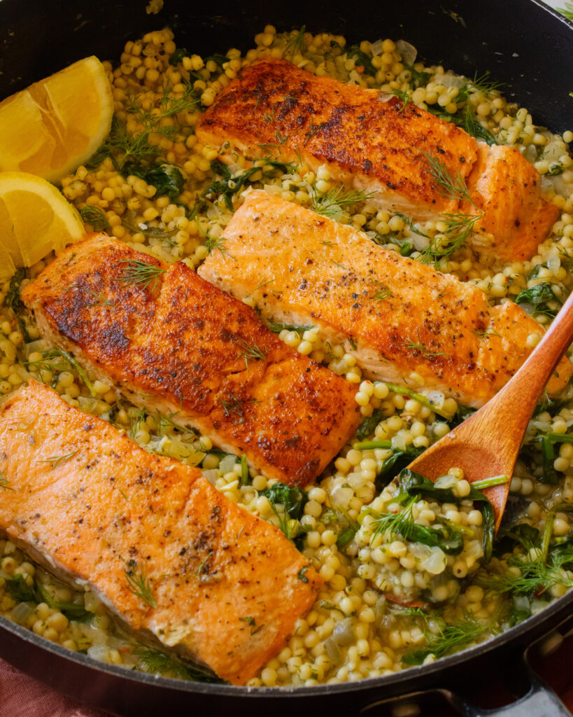 45 degree angle shot of One-Pan Herby Salmon and Couscous in the pan