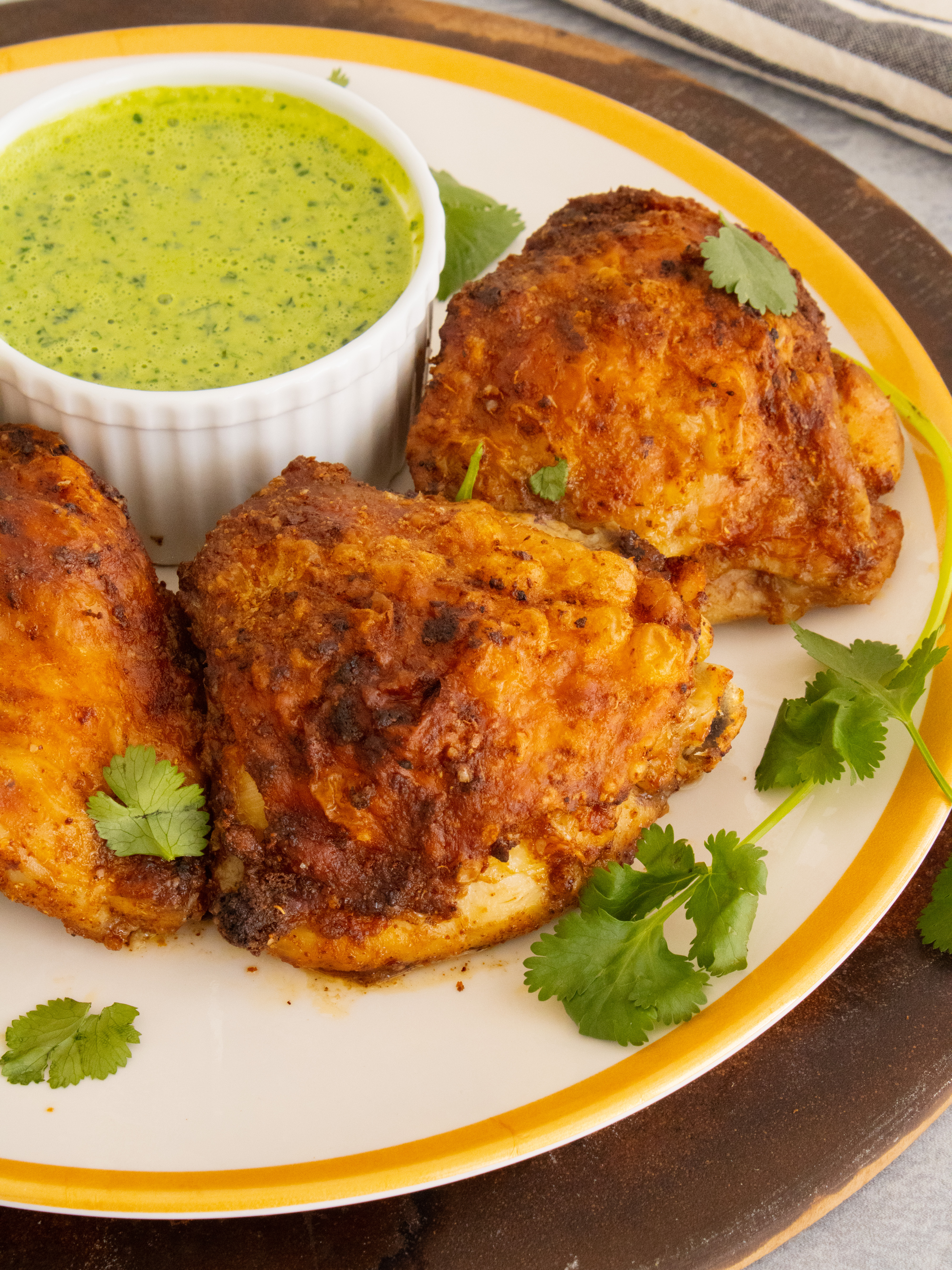 Chaat Masala Chicken Thighs on a plate served with cilantro chutney