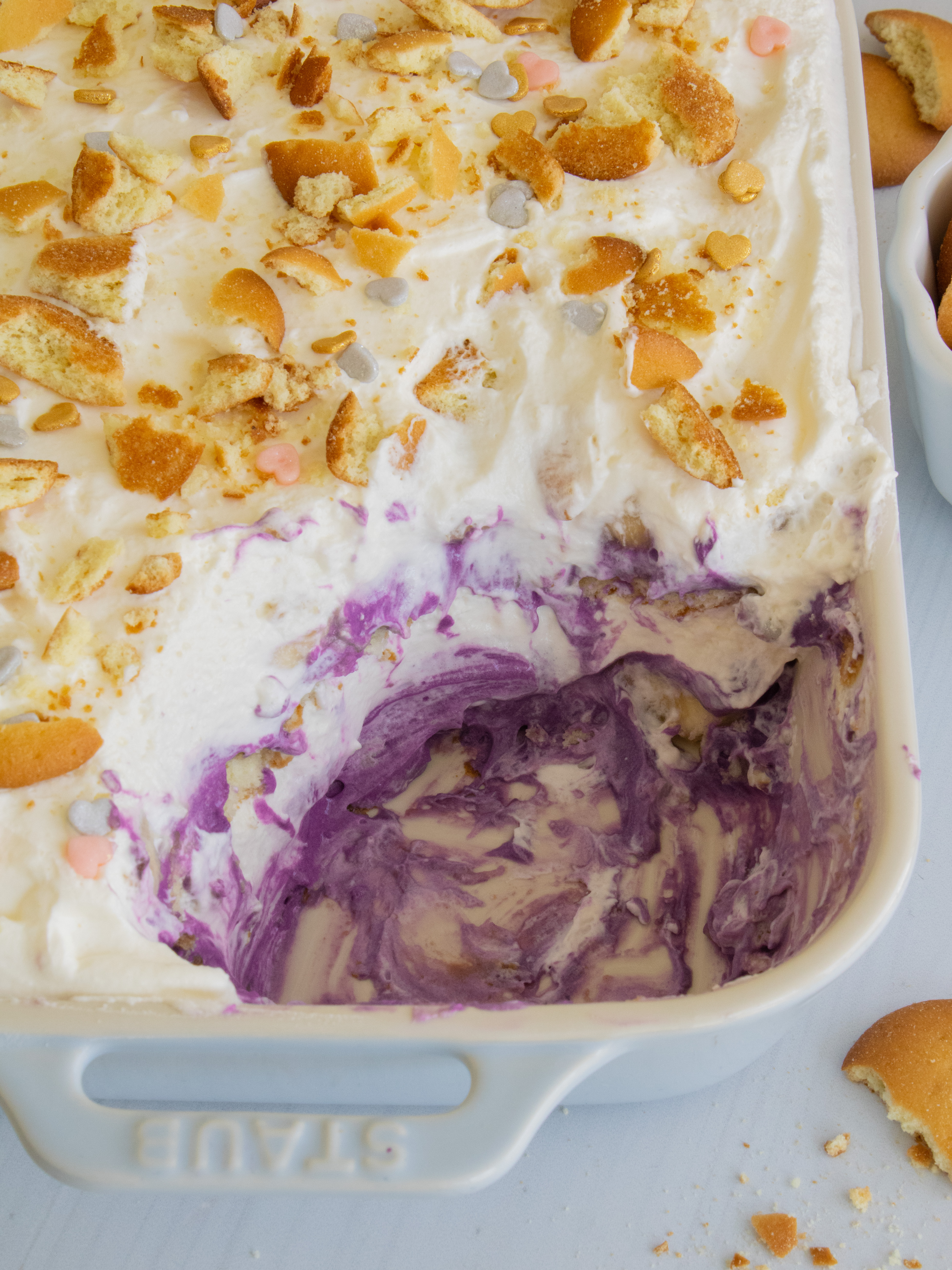 scoop of Ube Banana Pudding taken out of baking dish