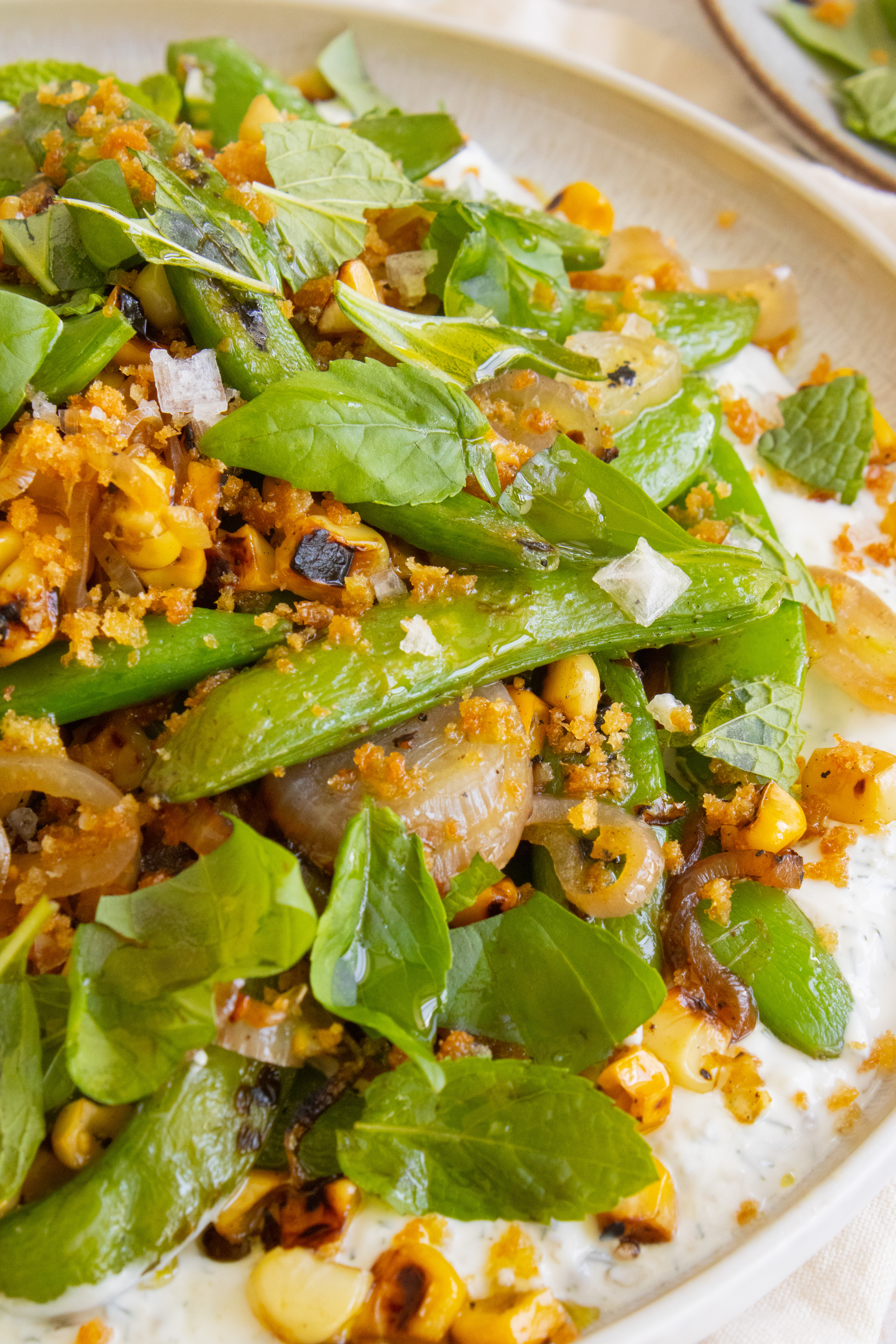 macro photo of Charred Snap Pea Corn Salad with flaky salt on top
