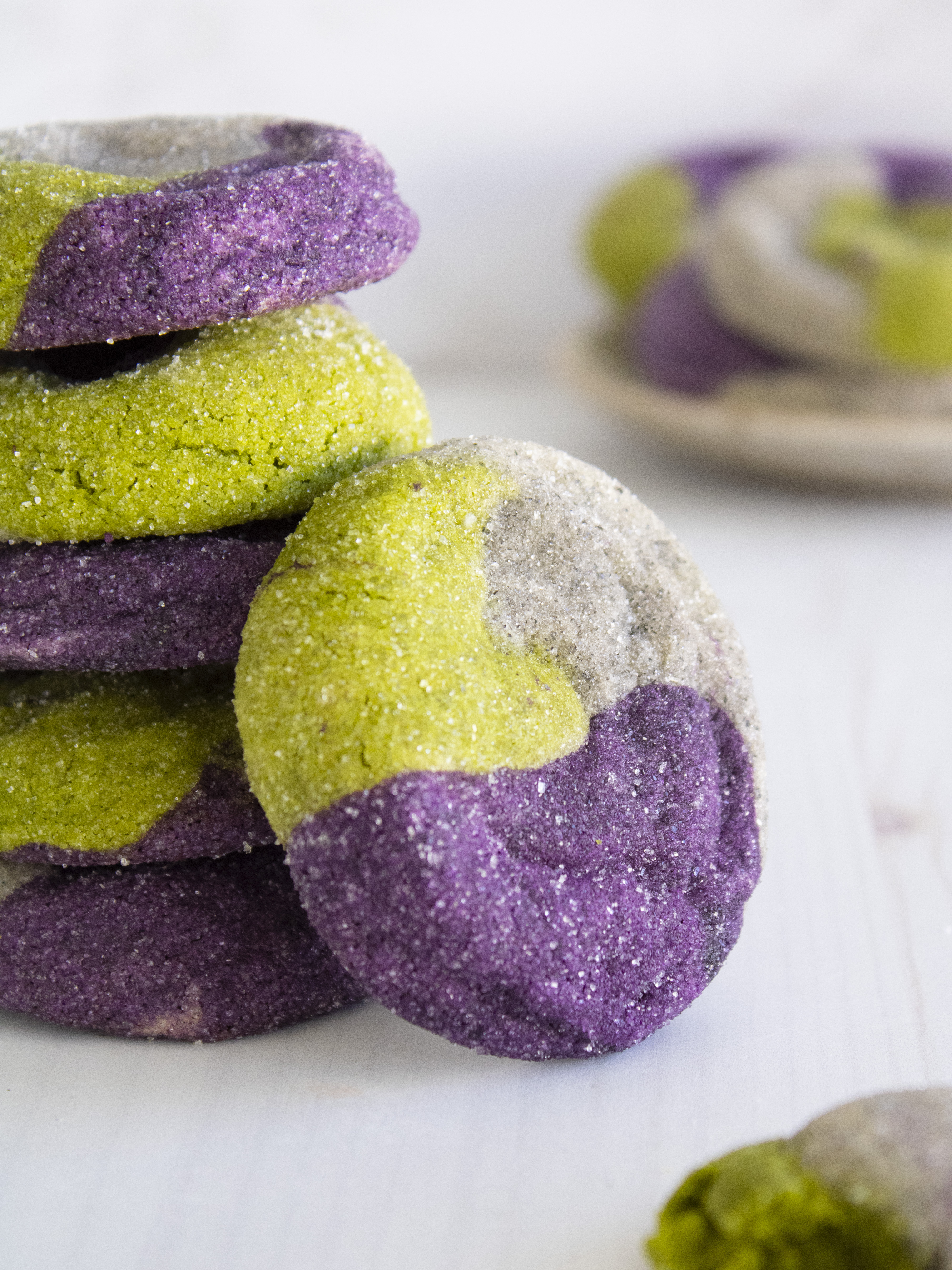 close up of Ube, Matcha & Black Sesame Neapolitan Cookies leaning on a stack of cookies