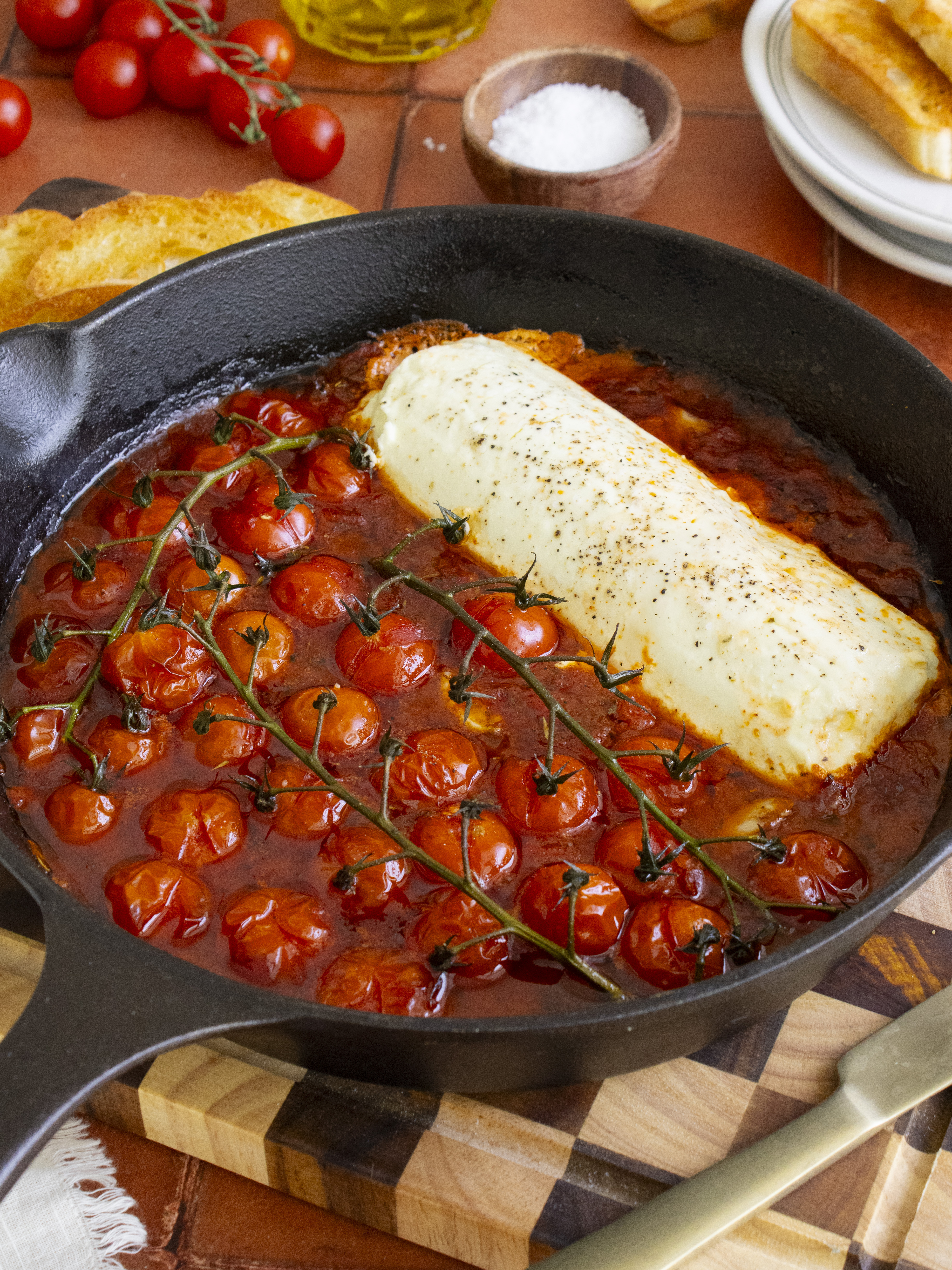 45 degree angle photo of Baked Tomato Paprika Goat Cheese Dip in cast iron pan