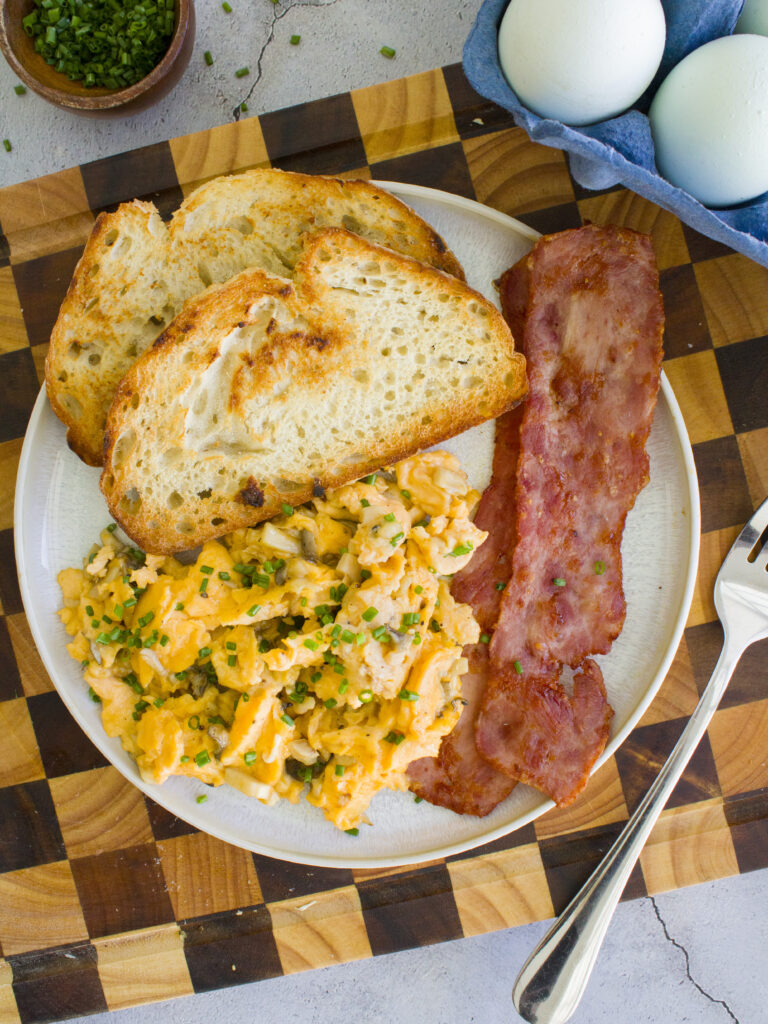 overhead photo of Soft Scrambled Eggs with Mushrooms on a plate with toast and turkey bacon