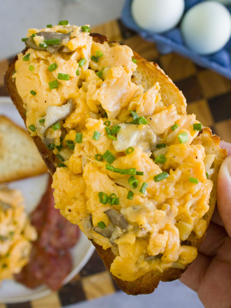 close up of Soft Scrambled Eggs with Mushrooms on a slice of toast