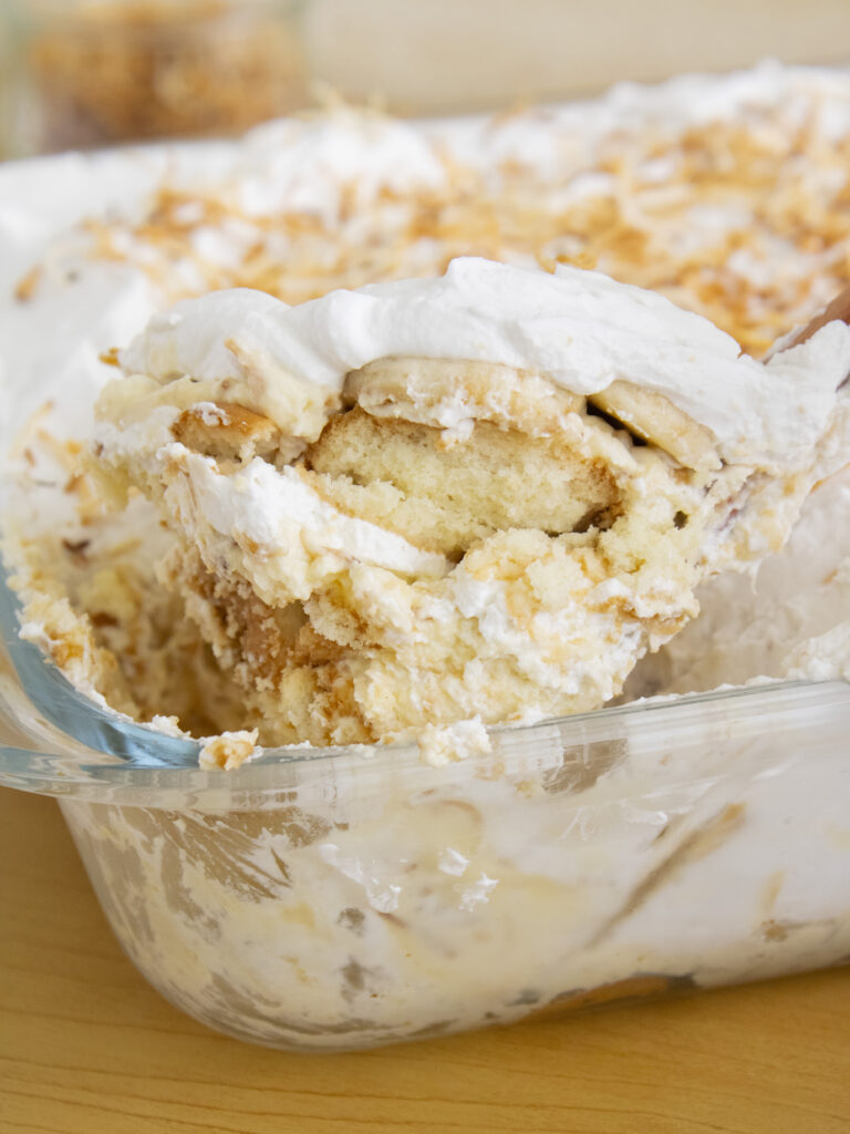 close up of a scoop of Coconut Cream Banana Pudding coming out of the tray