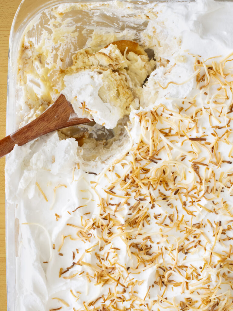 overhead shot of a scoop of Coconut Cream Banana Pudding in the dish