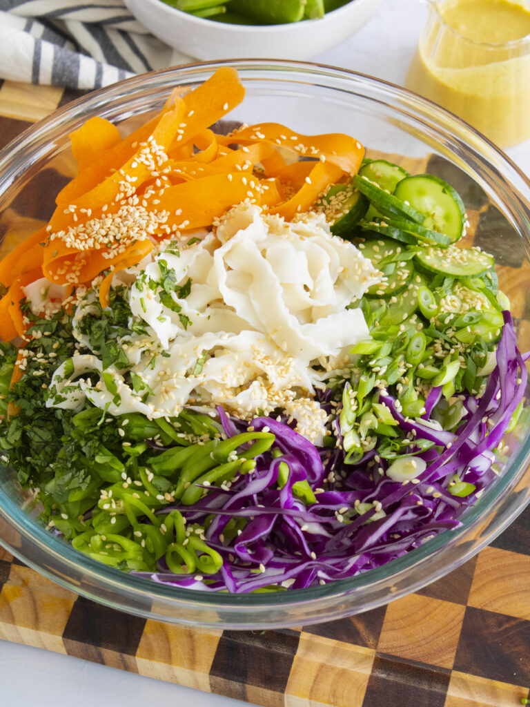 bowl of unmixed Coconut Curry Noodle Salad with the veggie on top