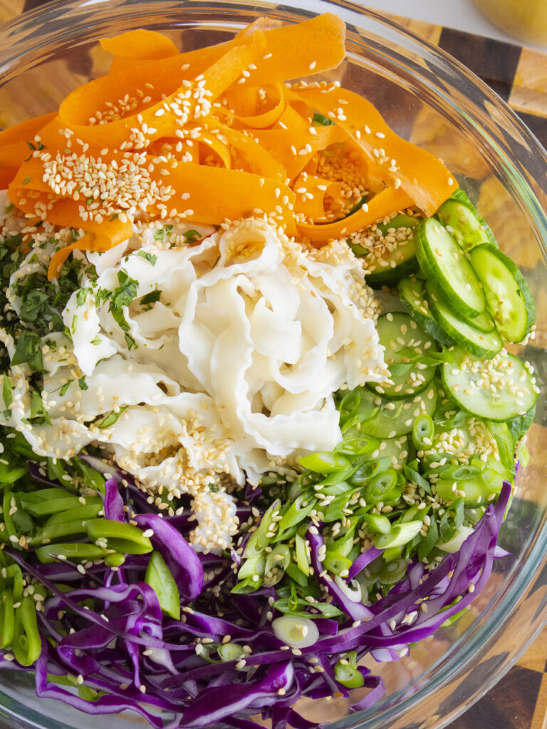 overhead close of shot of unmixed bowl of Coconut Curry Noodle Salad with veggies on top
