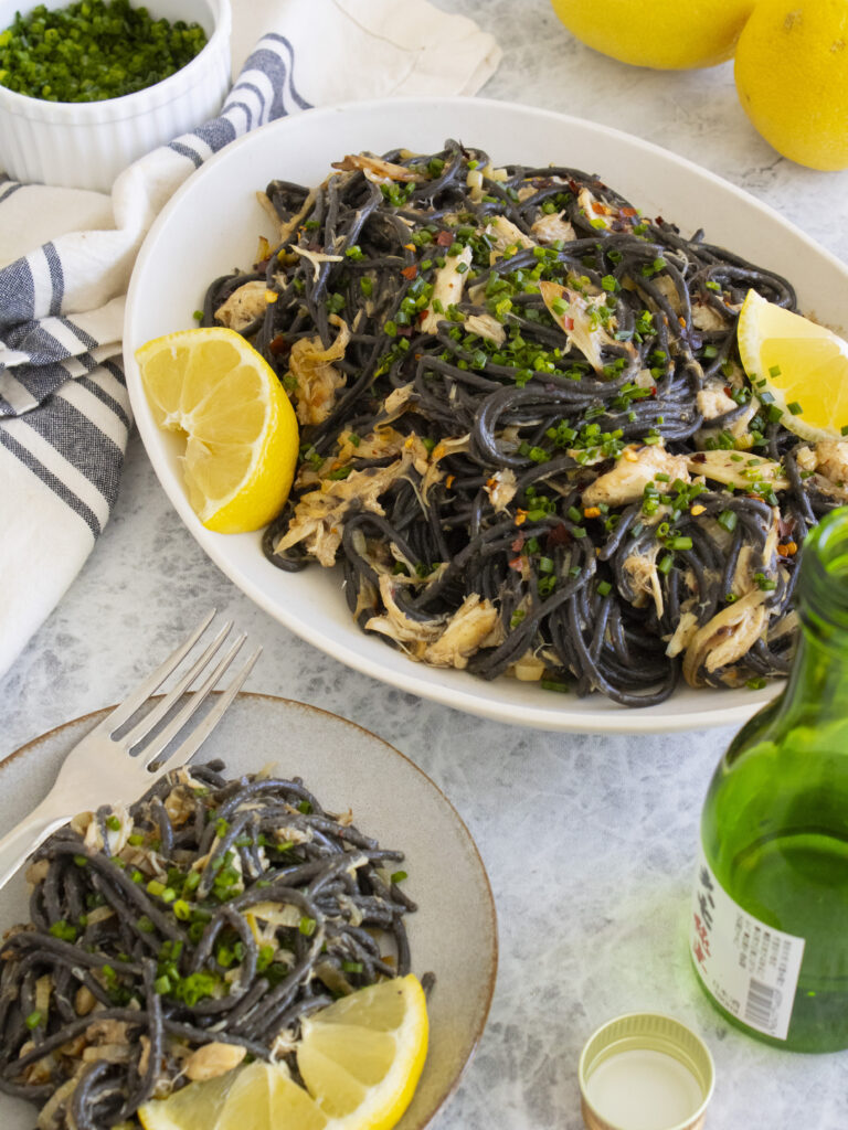Miso Leek Squid Ink Pasta on a serving platter with a small plate of it served off to the side