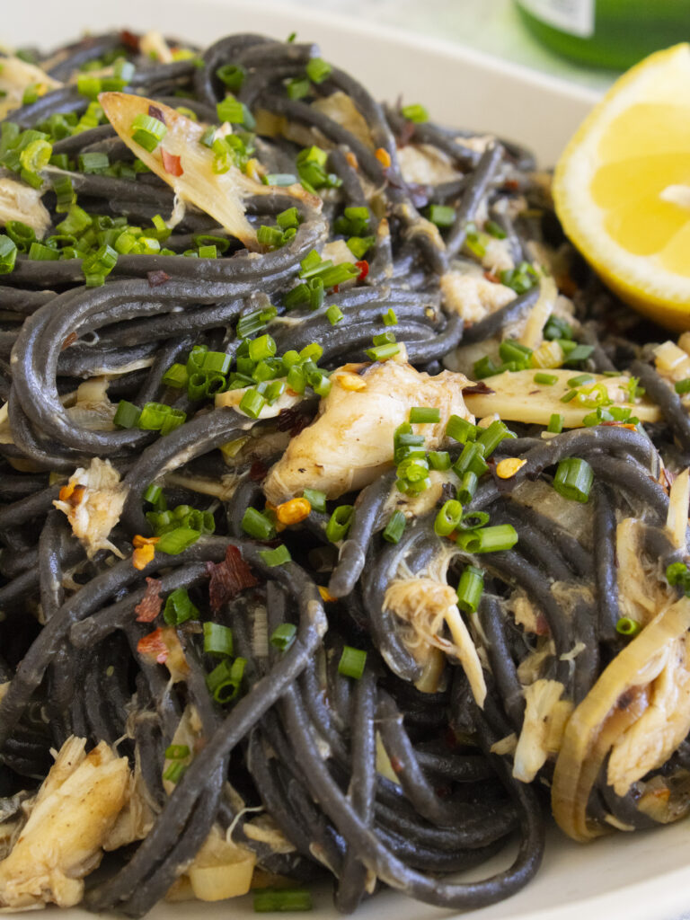 close up of crab meat in Miso Leek Squid Ink Pasta