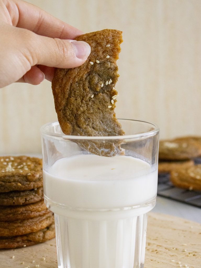 dipping one half of Pumpkin Hojicha Cookies into a glass of milk